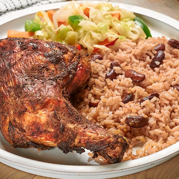 Negril Jamaican Restaurant's jerk chicken leg and thigh with rice and peas, and steamed cabbage.